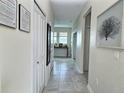 Bright hallway with neutral decor, tile flooring, doors, and stylish decorative touches at 703 Ocean Course Ave, Davenport, FL 33896