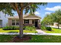 Charming single-story home with stone accents, manicured landscaping and a brick walkway leading to the front door at 8262 Bayview Crossing Dr, Winter Garden, FL 34787