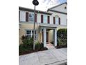 Inviting townhouse with tan siding, brown shutters, covered entryway, and landscaped front yard at 8271 Maritime Flag St # 109, Windermere, FL 34786