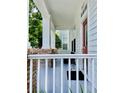 Inviting front porch with brick accents and columns, leading to a red front door at 907 Pawstand Rd, Celebration, FL 34747