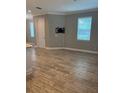 Bright living room featuring wood-look tile floors and a mounted TV, offering a modern and comfortable space at 9938 Eagle Creek Center Blvd, Orlando, FL 32832