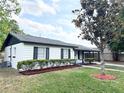 Charming single-story home with black shutters and a well-maintained landscaped yard with lush green grass at 1098 Leeway Ct, Orlando, FL 32810