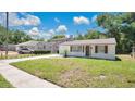 Inviting single-story home featuring a lush green lawn, with an extended driveway and cozy carport at 118 Deacon Jones Blvd, Orlando, FL 32810