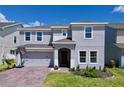 Two-story home with a brick paver driveway, landscaping and a two-car garage at 1181 Lone Palm Way, St Cloud, FL 34771