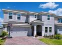 Two-story home with a brick paver driveway, landscaping and a two-car garage at 1181 Lone Palm Way, St Cloud, FL 34771