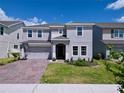 Two-story home with a brick paver driveway, landscaping and a two-car garage at 1181 Lone Palm Way, St Cloud, FL 34771