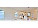 Open-concept living room with plenty of natural light and a kitchen featuring white cabinets at 12537 Encore At Ovation Way, Winter Garden, FL 34787