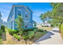 Stylish two-story home featuring vibrant blue siding and manicured landscaping, with a sidewalk at 1428 Reunion Blvd, Kissimmee, FL 34747