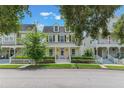 Attractive two-story yellow home with a cozy front porch and charming white picket fence at 206 Norfolk Pl, Celebration, FL 34747