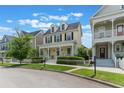 Inviting two-story yellow home featuring a classic front porch and well-manicured landscaping at 206 Norfolk Pl, Celebration, FL 34747