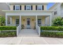 Inviting front porch with white columns, decorative wreath, and well-maintained landscaping at 206 Norfolk Pl, Celebration, FL 34747