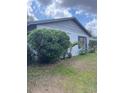 Home exterior with a well established bush and a small palm tree at 2071 Liston Ct, Orlando, FL 32811