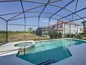 Relaxing screened in pool and spa with a view of the green space and lush landscaping at 219 Rosso Dr, Davenport, FL 33837