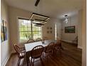 Bright dining room featuring wood floors, a modern light fixture, and views of the backyard at 2287 Park Maitland Ct, Maitland, FL 32751