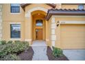 Home exterior featuring landscaped entrance, a two car garage, and address number 2630 above the door at 2630 Tranquility Way, Kissimmee, FL 34746
