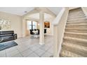 Bright living and dining area with tile flooring, modern furniture, and a staircase to the upper level at 2630 Tranquility Way, Kissimmee, FL 34746