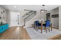 Welcoming foyer with front door, staircase, dining area, modern light fixture and wood-look floors at 2821 Columbus Ave, Clermont, FL 34715