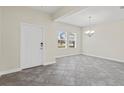 Spacious entryway featuring grey tile flooring, white walls, and a chandelier at 2901 Harvest Hill Ln, Orlando, FL 32824