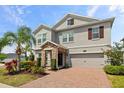 Two-story home featuring a manicured lawn, lovely stone accents, and a brick driveway at 2901 Harvest Hill Ln, Orlando, FL 32824