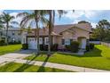 Inviting single-story house featuring a stone facade, two-car garage, and manicured lawn at 2902 Paddington Way, Kissimmee, FL 34747