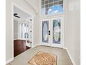 Bright foyer featuring tiled floors, high ceilings, decorative glass doors, and an open transition to the rest of the home at 3170 Zaharias Dr, Orlando, FL 32837