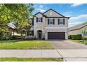 Charming two-story home with stone accents, a manicured lawn, and a brick driveway at 3425 Middlebrook Pl, Harmony, FL 34773