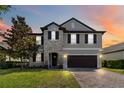 Beautiful two-story home featuring a stone facade, lush lawn and attached two car garage at 3425 Middlebrook Pl, Harmony, FL 34773