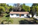 Charming single-story home featuring a manicured lawn and lush landscaping with a private drive at 453 E Jessup Ave, Longwood, FL 32750