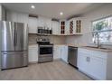Kitchen featuring stainless steel appliances, white cabinetry, wood countertops, and backsplash and bright window at 453 E Jessup Ave, Longwood, FL 32750