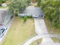 Inviting single-story home with well-kept lawn, long driveway, and mature landscaping at 4760 Danzig Ct, Orlando, FL 32811