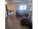 Open living space featuring laminate flooring, a comfortable couch, and a dining table and chairs at 4819 Apple Blossom Ln, St Cloud, FL 34771