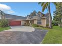 Inviting home showcases a red garage door, well-maintained landscaping, and a spacious driveway at 4885 Meadow Dr, St Cloud, FL 34772
