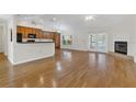 Open-concept living space with hardwood floors, a fireplace, and a view of the kitchen and dining area at 4885 Meadow Dr, St Cloud, FL 34772