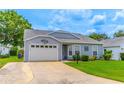 Single-story home with a white garage door, well-maintained lawn, and a concrete driveway at 5426 Astor St, Leesburg, FL 34748