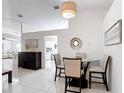 Dining area with a glass table, four chairs, neutral decor, and bright white walls at 5577 Sycamore Canyon Dr, Kissimmee, FL 34758