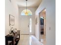 Bright foyer with white walls, decorative console table, and a decorative light fixture above the door at 5577 Sycamore Canyon Dr, Kissimmee, FL 34758