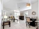 Spacious living room with white tile floors, comfortable seating, and an open layout to the dining area at 5577 Sycamore Canyon Dr, Kissimmee, FL 34758