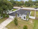 Overhead view of gray house with lush lawn, mature trees and white picket fence at 5642 Chukar Dr, Orlando, FL 32810