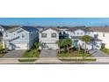 Two-story home featuring a well-maintained lawn and a two-car garage on a sunny day at 7184 Oakmoss Loop, Davenport, FL 33837