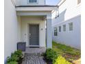 The front door with a small porch provides a welcoming entrance to the home at 7184 Oakmoss Loop, Davenport, FL 33837