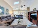 Spacious living room featuring vaulted ceilings, skylights, tile flooring, and comfortable seating at 8019 Indian Creek Blvd, Kissimmee, FL 34747