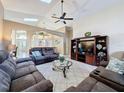 Bright and airy living area with vaulted ceiling, tile floors, comfortable sofas, and entertainment center at 8019 Indian Creek Blvd, Kissimmee, FL 34747