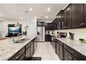 Modern kitchen with granite countertops, stainless steel appliances, and stylish dark cabinetry at 971 Paradise Dr, Davenport, FL 33897