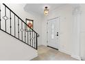 Elegant foyer with tile floors, a staircase with iron railings, and a stained glass window at 1047 Banks Rose St, Kissimmee, FL 34747