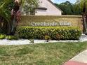 Creekside Villas signage featuring a brick wall with lush greenery and tropical landscaping at 108 Creekside Way, Orlando, FL 32824