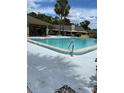 Community pool with clear blue water, palm trees and lounge chairs for relaxing in the sun at 108 Creekside Way, Orlando, FL 32824