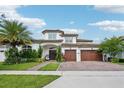 Beautiful two-story home with a three-car garage, an inviting entrance, and lush landscaping under a bright blue sky at 13136 Alderley Drive Dr, Orlando, FL 32832