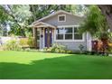 Inviting home with neat landscaping, healthy green yard, cozy porch, and freshly painted exterior at 1407 Noble Pl, Orlando, FL 32801