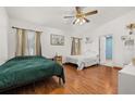 Comfortable bedroom with hardwood floors, two windows, ceiling fan and access to an ensuite bathroom at 1543 Reade Cir, St Cloud, FL 34772