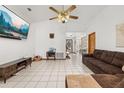 Spacious living room with tile floors, vaulted ceilings, fan, and ample natural light with an open view to the dining area at 1543 Reade Cir, St Cloud, FL 34772